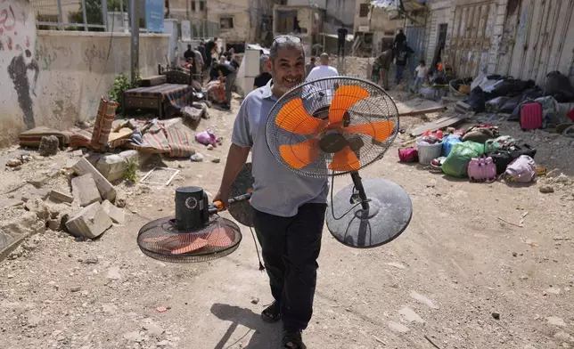 Residents of the now evacuated refugee camp of Tulkarem return to collect belongings before the destruction of their homes as Israeli forces prepare to carry out the demolition of 116 homes across the two refugee camps of the Israeli occupied West Bank city of Tulkarem, Friday, May 2, 2025. (AP Photo/Nasser Nasser)