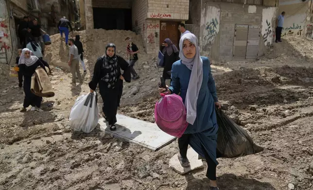 Residents of the now evacuated refugee camp of Tulkarem return to collect belongings before the destruction of their homes as Israeli forces prepare to carry out the demolition of 116 homes across the two refugee camps of the Israeli occupied West Bank city of Tulkarem, Friday, May 2, 2025. (AP Photo/Nasser Nasser)