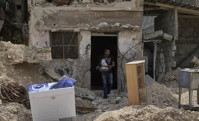 Residents of the now evacuated refugee camp of Tulkarem return to collect belongings before the destruction of their homes as Israeli forces prepare to carry out the demolition of 116 homes across the two refugee camps of the Israeli occupied West Bank city of Tulkarem, Friday, May 2, 2025. (AP Photo/Nasser Nasser)