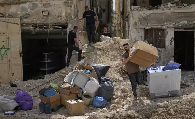 Residents of the now evacuated refugee camp of Tulkarem return to collect belongings before the destruction of their homes as Israeli forces prepare to carry out the demolition of 116 homes across the two refugee camps of the Israeli occupied West Bank city of Tulkarem, Friday, May 2, 2025. (AP Photo/Nasser Nasser)