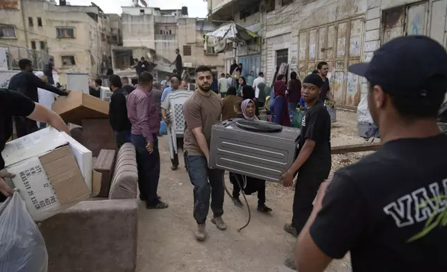 Residents of the now evacuated refugee camp of Tulkarem return to collect belongings before the destruction of their homes as Israeli forces prepare to carry out the demolition of 116 homes across the two refugee camps of the Israeli occupied West Bank city of Tulkarem, Friday, May 2, 2025. (AP Photo/Nasser Nasser)