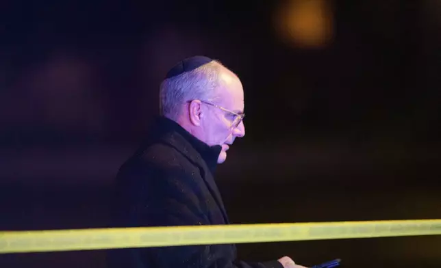 A man walks from the scene as law enforcement work the area after two staff members of the Israeli Embassy in Washington were shot and killed outside the Capital Jewish Museum, Thursday, May 22, 2025, in Washington.(AP Photo/Rod Lamkey, Jr.)