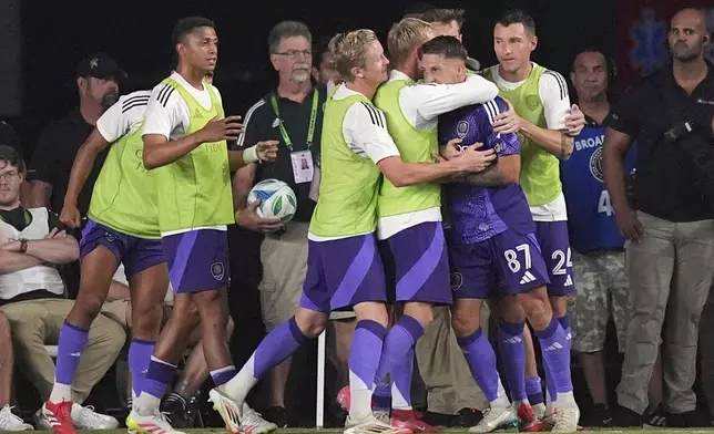 Orlando City forward Marco Pasalic (87) celebrates with teammates after scoring his side's second goal against Inter Miami during the second half of an MLS soccer match, Sunday, May 18, 2025, in Fort Lauderdale, Fla. (AP Photo/Rebecca Blackwell)