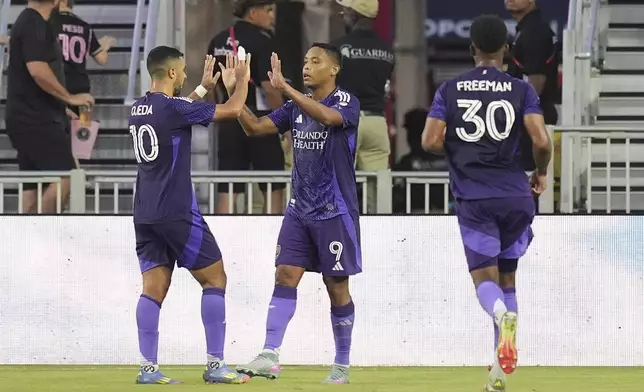 Orlando City forward Luis Muriel (9) celebrates with teammates after scoring his side's first goal against Inter Miami during the first half of an MLS soccer match, Sunday, May 18, 2025, in Fort Lauderdale, Fla. (AP Photo/Rebecca Blackwell)