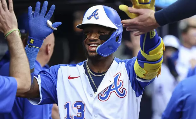 Atlanta Braves' Ronald Acuna Jr. (13) high-fives teammates in the dugout after hitting a two-run home run in the sixth inning of a baseball game against the San Diego Padres, Saturday, May 24, 2025, in Atlanta. (AP Photo/Colin Hubbard)