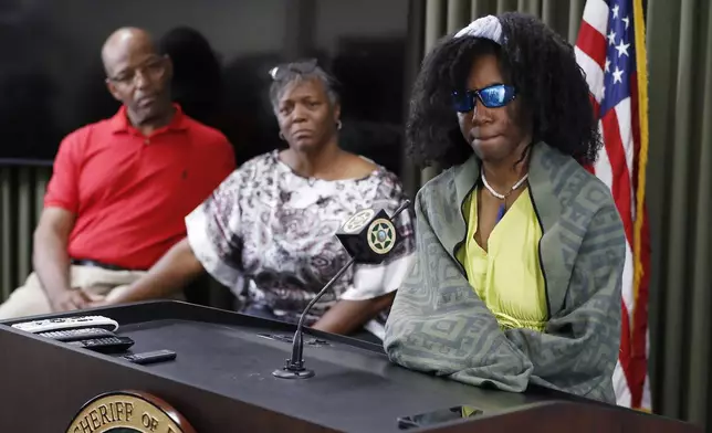 Tiffany Slaton, a hiker found in the High Sierra after going missing for three weeks, speaks during a press conference as her parents Bobby and Fredrina look on, Friday, May 16, 2025 in Fresno, Calif. (AP Photo/Gary Kazanjian)