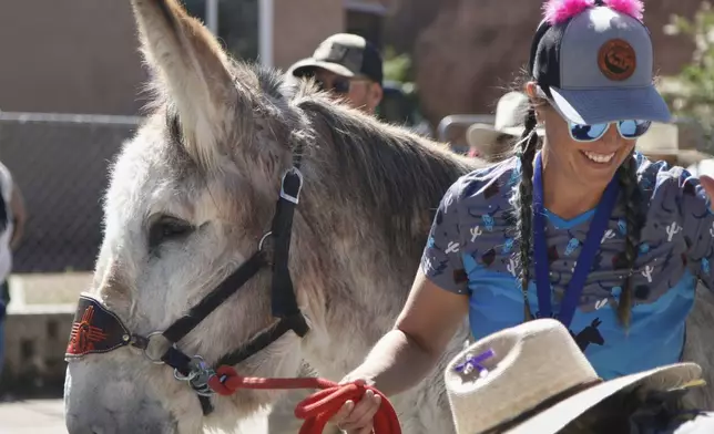 Pack burros and their human companions race through the streets of a former mining town and across backcountry desert trails in Cerrillos, N.M., on Saturday, May 3, 2025. (AP Photo/Morgan Lee)