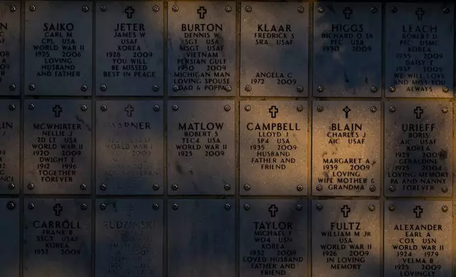 The sun spills over a memorial wall during Memorial Day on Monday, May 26, 2025, at Great Lakes National Cemetery in Holly Township, Mich. (Ayrton Breckenridge/The Flint Journal via AP)
