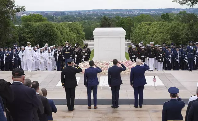 President Donald Trump, standing right, salutes at the Tomb of the Unknown Soldier, on Memorial Day at Arlington National Cemetery, in Arlington, Va., Monday, May 26, 2025. (AP Photo/Jacquelyn Martin)