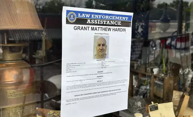 A flier looking for Grant Hardin hangs on the glass of a business, Thursday, May 29, 2025, in downtown Calico Rockt, Ark. (AP Photo/Nicholas Ingram)
