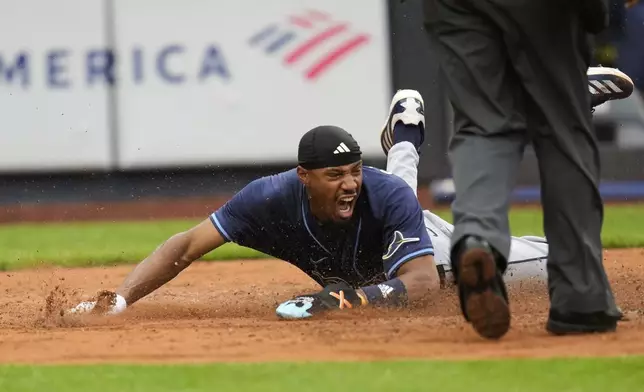 Tampa Bay Rays' Chandler Simpson reacts after diving home on a single hit by Yandy Díaz during the fourth inning of a baseball game against the New York Yankees, Sunday, May 4, 2025, in New York. (AP Photo/Seth Wenig)