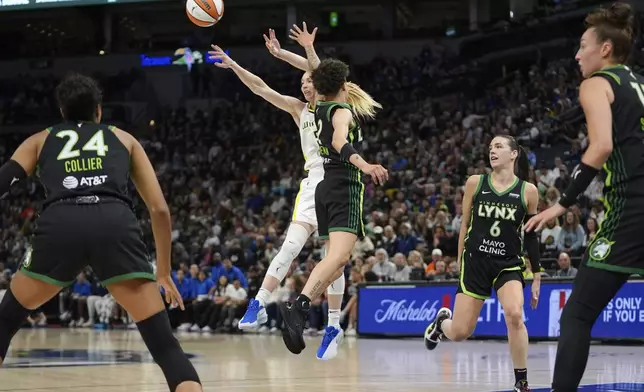 Dallas Wings guard Paige Bueckers (5), back, passes around Minnesota Lynx guard Natisha Hiedeman (2) during the first half of a WNBA basketball game Wednesday, May 21, 2025, in Minneapolis. (AP Photo/Abbie Parr)
