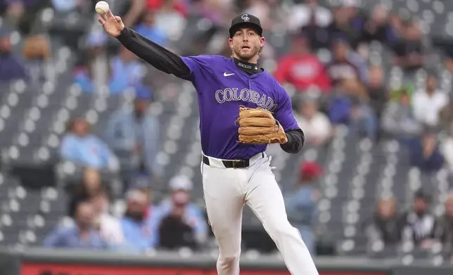 Colorado Rockies third baseman Ryan McMahon throws to first base to put out Philadelphia Phillies' Trea Turner in the first inning of a baseball game Monday, May 19, 2025, in Denver. (AP Photo/David Zalubowski)