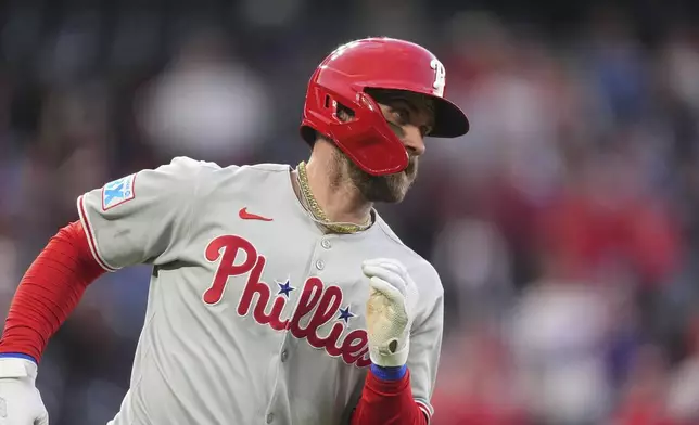 Philadelphia Phillies' Bryce Harper rounds first base after hitting an RBI single off Colorado Rockies starting pitcher Kyle Freeland in the fifth inning of a baseball game Monday, May 19, 2025, in Denver. (AP Photo/David Zalubowski)