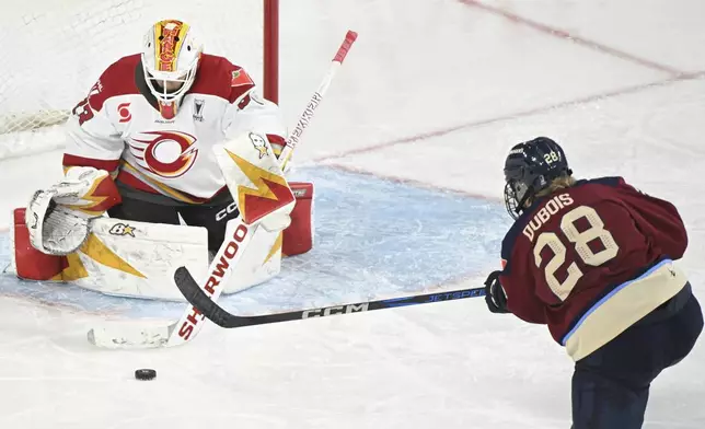 Montreal Victoire's Catherine Dubois (28) shoots against Ottawa Charge goaltender Gwyneth Philips, left, during second overtime period PWHL playoff hockey action in Laval, Quebec, Sunday, May 11, 2025. (Graham Hughes/The Canadian Press via AP)