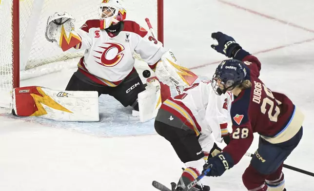 Montreal Victoire's Catherine Dubois (28) scores against Ottawa Charge goaltender Gwyneth Philips, left, during fourth overtime period PWHL playoff hockey action in Laval, Quebec, Sunday, May 11, 2025. (Graham Hughes/The Canadian Press via AP)