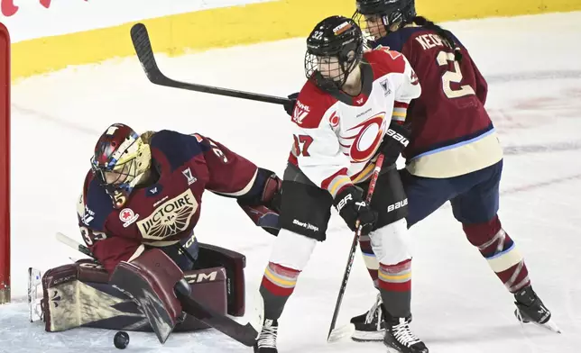 Ottawa Charge's Rebecca Leslie (37) moves in against Montreal Victoire goaltender Ann-Renee Desbiens (35) as Victoire's Mariah Keopple (2) defends during second-period PWHL hockey playoff action in Laval, Quebec, Sunday, May 11, 2025. (Graham Hughes/The Canadian Press via AP)