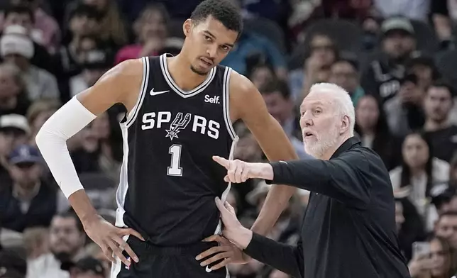 FILE - San Antonio Spurs head coach Gregg Popovich, right, talks with center Victor Wembanyama (1) during the first half of an NBA basketball game against the Los Angeles Lakers in San Antonio, Wednesday, Dec. 13, 2023. (AP Photo/Eric Gay, File)