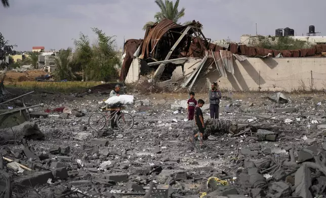 Palestinians inspect the rubble of the Al-Zainati family's home, destroyed by Israeli airstrikes in Khan Younis, Gaza Strip, on Thursday, May 15, 2025. (AP Photo/Abdel Kareem Hana)