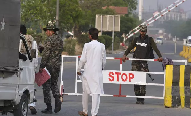 A Pakistani paramilitary soldier searches a vehicle as another stands guard at a checkpoint in Wagah, a joint border crossing point on the Pakistan and India border, near Lahore, Pakistan, Wednesday, April 30, 2025.(AP Photo/K.M. Chaudary)