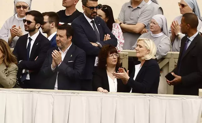 Italian Deputy Prime Minister Matteo Salvini, center, left, and French far-right leader Marine Le Pen, center right, are seen in the crowd as they attend Pope Leo XIV's appearance at the central balcony of St. Peter's Basilica for his first Sunday blessing after his election, in St. Peter's Square at the Vatican, Sunday, May 11, 2025. (Cecilia Fabiano/LaPresse via AP)