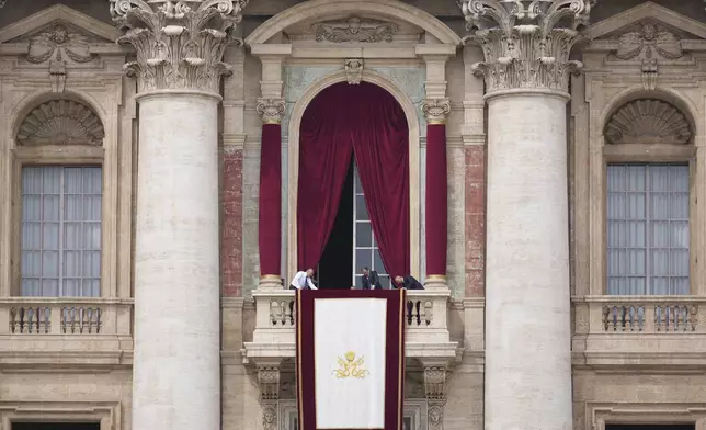 Vatican clerks prepare the loggia ahead of Pope Leo XIV's appearance at the central balcony of St. Peter's Basilica for his first Sunday blessing after his election, in St. Peter's Square at the Vatican, Sunday, May 11, 2025.(AP Photo/Andrew Medichini)
