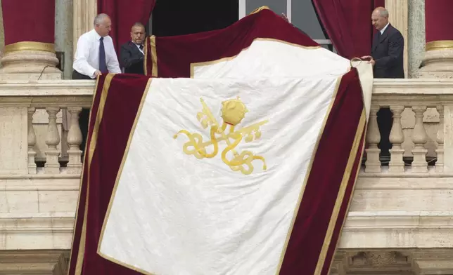 Vatican clerks prepare the loggia ahead of Pope Leo XIV appearance at the central balcony of St. Peter's Basilica for his first Sunday blessing after his election, in St. Peter's Square at the Vatican, Sunday, May 11, 2025.(AP Photo/Andrew Medichini)