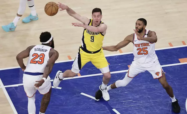 Indiana Pacers guard T.J. McConnell (9) passes the ball against New York Knicks center Mitchell Robinson (23) and forward Mikal Bridges (25) during the fourth quarter of Game 2 of the NBA basketball Eastern Conference final, Friday, May 23, 2025, in New York. (AP Photo/Adam Hunger)