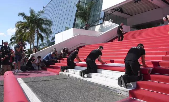 Crew members install the red carpet at the Palais des Festivals ahead of the opening ceremony of the 78th international film festival, Cannes, southern France, Tuesday, May 13, 2025. (Photo by Lewis Joly/Invision/AP)