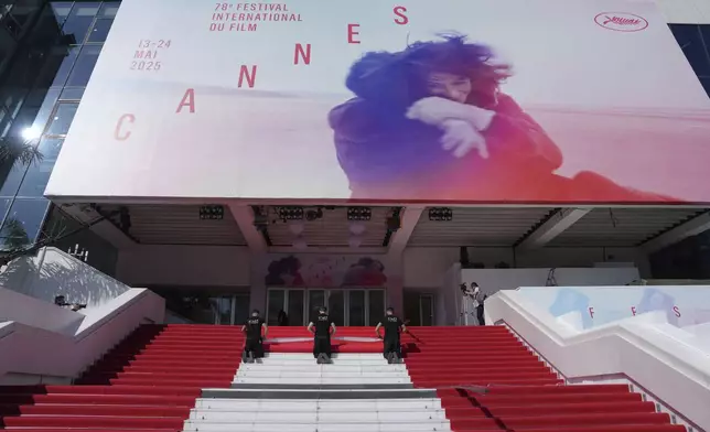 Crew members install the red carpet at the Palais des Festivals ahead of the opening ceremony of the 78th international film festival, Cannes, southern France, Tuesday, May 13, 2025. (Photo by Lewis Joly/Invision/AP)