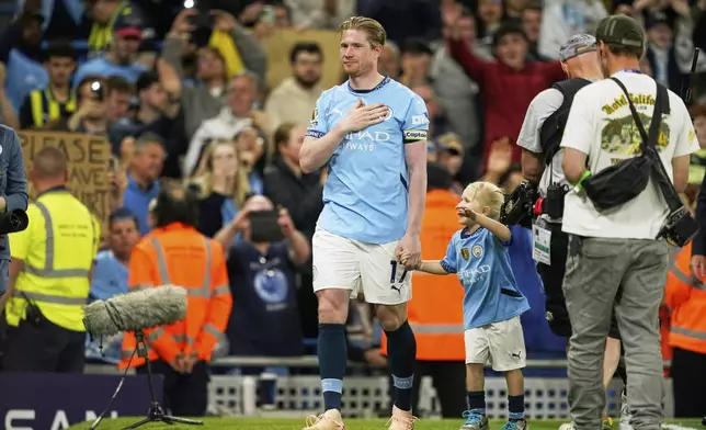 Manchester City's Kevin De Bruyne greets supporters after his final home game during the English Premier League soccer match between Manchester City and Bournemouth at the Etihad stadium in Manchester, England, Tuesday, May 20, 2025. (AP Photo/Dave Thompson)