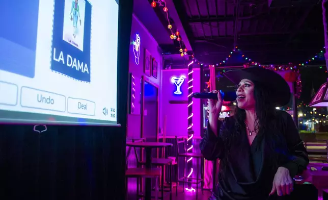 Audrey Campos announces the Loteria card La Dama during a Loteria game night at Jackie O's Cocktail Club in Fort Worth, Texas, Tuesday, May 27, 2025. (AP Photo/Ronaldo Bolaños)