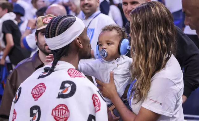 Oklahoma City Thunder guard Shai Gilgeous-Alexander, left, meets with his wife, Hailey Summers, and their son Ares Alexander following Game 1 of an NBA basketball Western Conference Finals playoff series against the Minnesota Timberwolves Tuesday, May 20, 2025, in Oklahoma City. (AP Photo/Nate Billings)