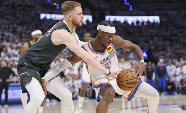 Minnesota Timberwolves guard Donte DiVincenzo, left, applies pressure on Oklahoma City Thunder guard Shai Gilgeous-Alexander during the second half of Game 1 of an NBA basketball Western Conference Finals playoff series Tuesday, May 20, 2025, in Oklahoma City. (AP Photo/Nate Billings)
