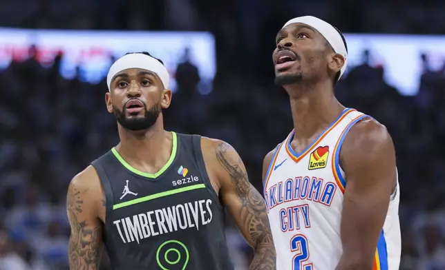 Minnesota Timberwolves guard Nickeil Alexander-Walker (9) stands next to his cousin Oklahoma City Thunder guard Shai Gilgeous-Alexander during the second half of Game 1 of an NBA basketball Western Conference Finals playoff series Tuesday, May 20, 2025, in Oklahoma City. (AP Photo/Nate Billings)
