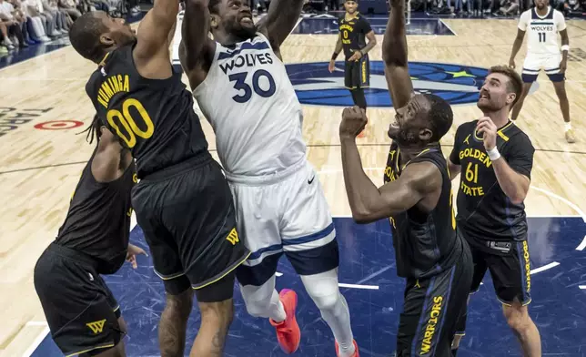 Minnesota Timberwolves' Julius Randle (30) shoots defended by four of the Golden State Warriors in the second half of Game 1 of an NBA basketball second-round playoff series, Tuesday, May 6, 2025, in Minneapolis. (Carlos Avila Gonzalez/San Francisco Chronicle via AP)