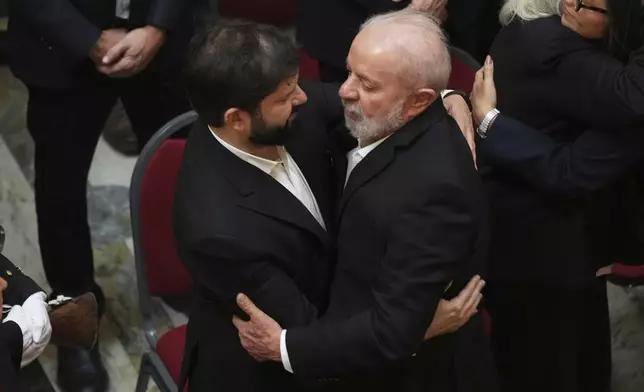 Brazil's President Luiz Inacio Lula Da Silva, right, and Chile's President Gabriel Boric embrace during funeral ceremonies for former Uruguayan President Jose Mujica at the Legislative Palace in Montevideo, Uruguay, Thursday, May 15, 2025. (AP Photo/Matilde Campodonico)