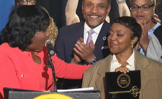 In this image made from video, Philadelphia's Mayor Cherelle Parker, left, honors actor Quinta Brunson with a key to the city in a ceremony dedicating a mural at Brunson’s alma mater, Andrew Hamilton School, which was the inspiration for her award-winning show “Abbott Elementary” Wednesday, May 28, 2025, in Philadelphia. (AP Photo/Tassanee Vejpongsa)