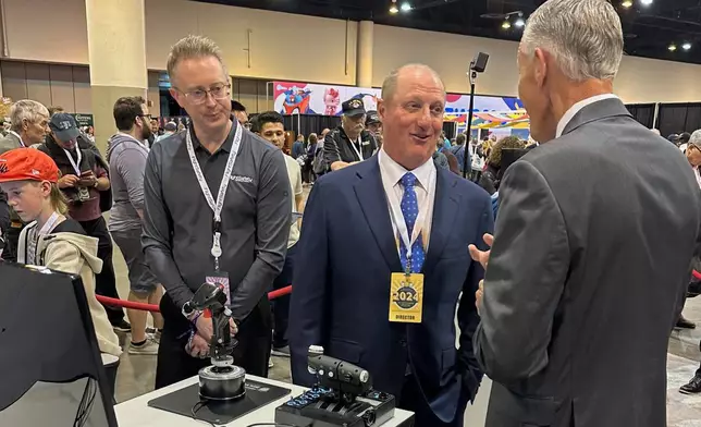 FILE - Berkshire Hathaway Vice Chairman Greg Abel checks out the flight simulators offered by one of Berkshires companies, Flight Safety as he toured the exhibit hall Friday, May 3, 2024, in Omaha, Neb. ahead of Saturday's meeting. (AP Photo/Josh Funk, File)