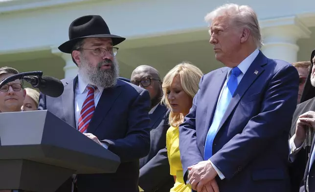 Rabbi Levi Shemtov speaks as President Donald Trump, from right, pastor Paula White and House Speaker Mike Johnson, R-La., left, listen during a National Day of Prayer event in the Rose Garden of the White House, Thursday, May 1, 2025, in Washington. (AP Photo/Evan Vucci)