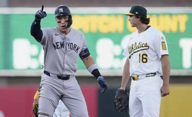 New York Yankees' Aaron Judge, left, reacts next to Athletics first baseman Nick Kurtz (16) after hitting a double during the first inning of a baseball game Friday, May 9, 2025, in West Sacramento, Calif. (AP Photo/Godofredo A. Vásquez)