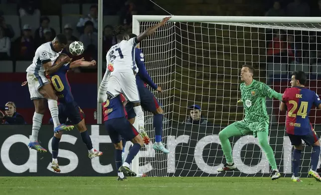 Inter Milan's Denzel Dumfries, left, scores his side's third goal during the Champions League semifinal first leg soccer match between Barcelona and Inter Milan at the Lluis Companys Olympic Stadium in Barcelona, Spain, Wednesday, April 30, 2025. (AP Photo/Joan Monfort)