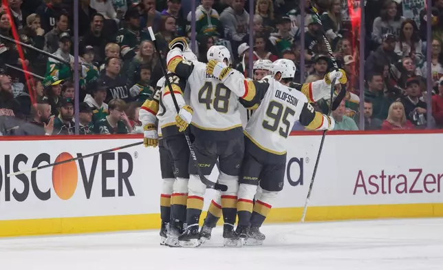 Vegas Golden Knights defenseman Shea Theodore (27) celebrates with teammates after scoring a power play goal during the first period of Game 6 of a first-round NHL hockey playoff series against the Minnesota Wild, Thursday, May 1, 2025, in St. Paul, Minn. (AP Photo/Bailey Hillesheim)
