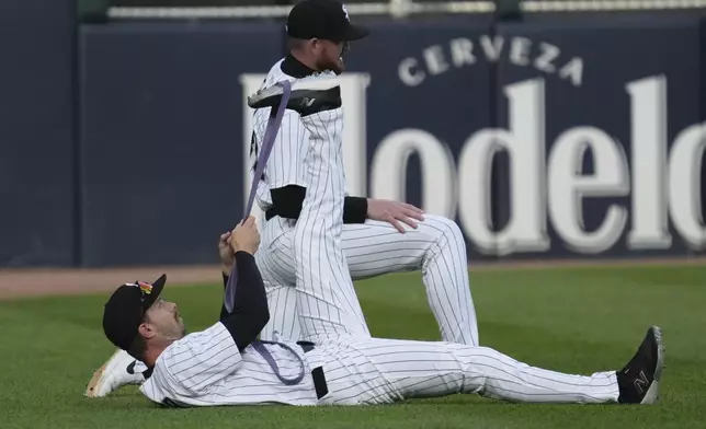 Chicago White Sox's Austin Slater, bottom, and Tim Elko warm up before a baseball game against the Seattle Mariners in Chicago, Monday, May 19, 2025. (AP Photo/Nam Y. Huh)