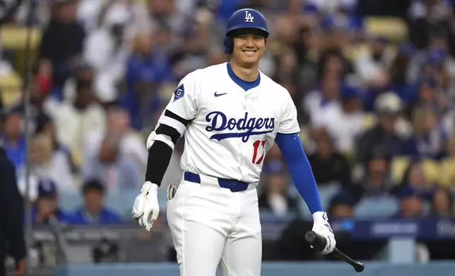Los Angeles Dodgers' Shohei Ohtani smiles toward the Los Angeles Angels dugout before batting during the first inning of a baseball game Friday, May 16, 2025, in Los Angeles. (AP Photo/Mark J. Terrill)