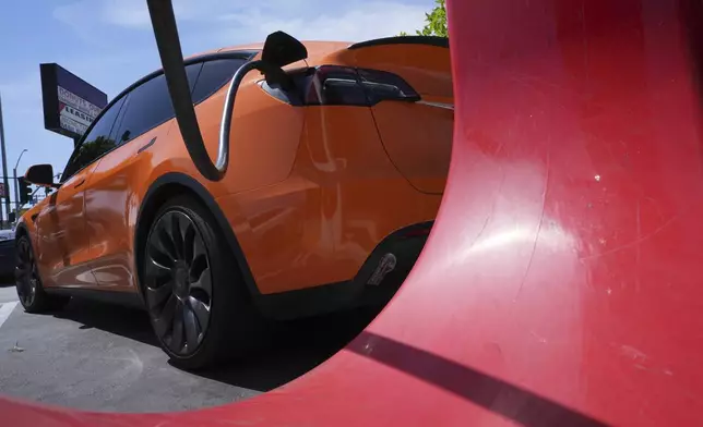An electric vehicle is seen charging at a charging station Thursday, May 22, 2025, in Long Beach, Calif. (AP Photo/Damian Dovarganes)