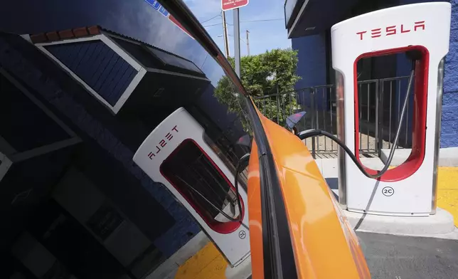 An electric vehicle is seen charging at a charging station Thursday, May 22, 2025, in Long Beach, Calif. (AP Photo/Damian Dovarganes)