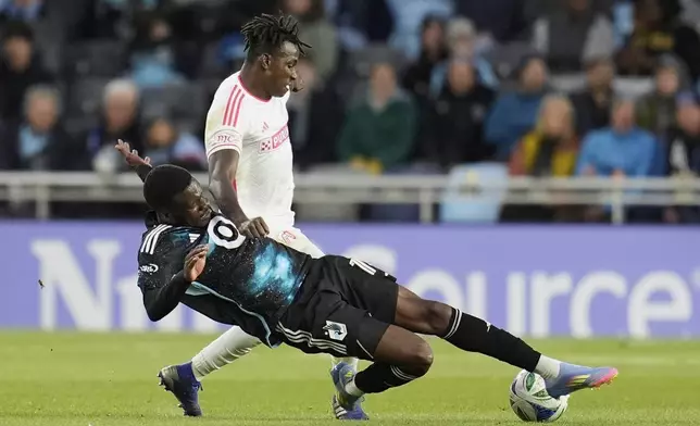 Minnesota United forward Tani Oluwaseyi, bottom, reaches for the ball as St. Louis City defender Joshua Yaro, top, defends during the first half of an MLS soccer match Saturday, May 17, 2025, in St. Paul, Minn. (AP Photo/Abbie Parr)