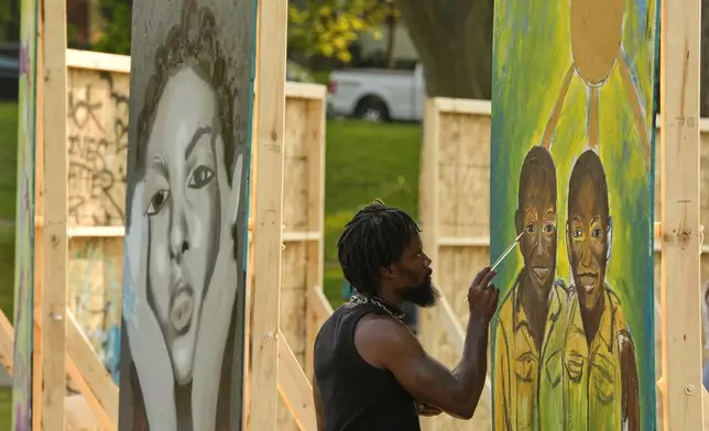 Flahn Manly works on a painting in a park near George Floyd Square on the five-year anniversary of Floyd's death, Sunday, May 25, 2025, in Minneapolis. (AP Photo/Abbie Parr)