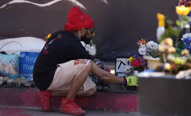 A person visits the spot of George Floyd's murder at George Floyd Square on the five-year anniversary of Floyd's death, Sunday, May 25, 2025, in Minneapolis. (AP Photo/Abbie Parr)